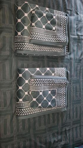 a group of pillows sitting on top of a bed at Appartement centre village vue mer - Relais Fleuri in Ault