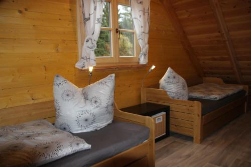 a room with two beds and a window in a cabin at Ferienhaus Wolfs-Revier in Drognitz