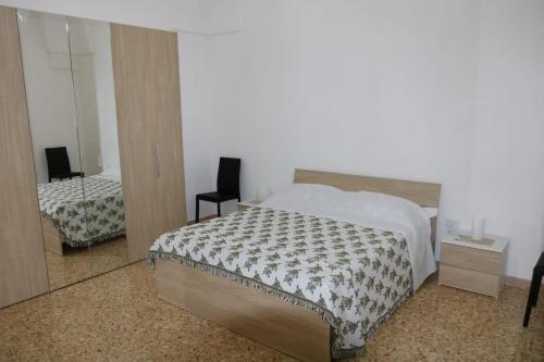 sypialnia z łóżkiem i lustrem w obiekcie Casa Vacanze Res Publica Domus w mieście Avetrana