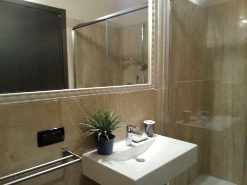 een badkamer met een wastafel, een douche en een spiegel bij Hotel La Vecchia Reggio in Reggio Emilia