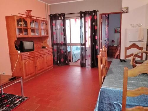 a living room with a table and a tv in a room at Arrifana Summer Flat in Aljezur