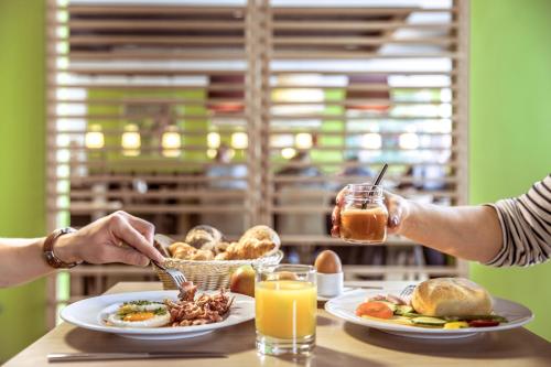 two people sitting at a table with plates of food at TUI BLUE Schladming in Schladming