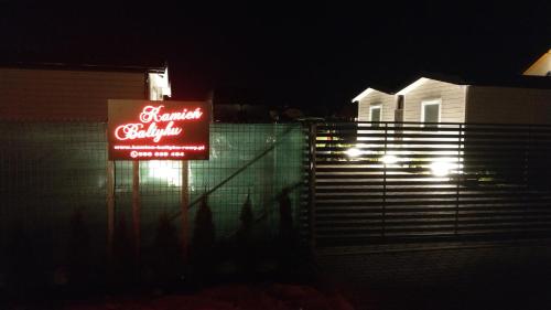 a sign in front of a house at night at Kamień Bałtyku Rowy in Rowy