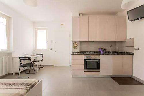 uma cozinha com armários brancos e uma mesa num quarto em Casa dei Marmi - in Toscana 10 min dal mare em Massa
