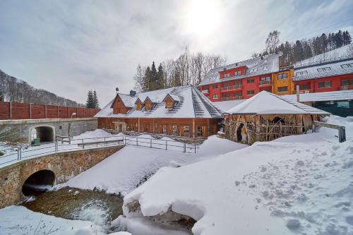 a snow covered city with a bridge and buildings at Chalupa Baba-jaga Žacléř in Žacléř