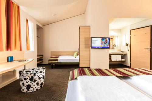 a hotel room with a bed and a tv at TUI BLUE Schladming in Schladming
