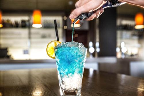 a person is making a blue drink on a table at TUI BLUE Schladming in Schladming