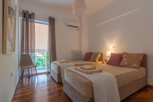 Habitación de hotel con 2 camas y ventana en Athenian Apartment, en Atenas