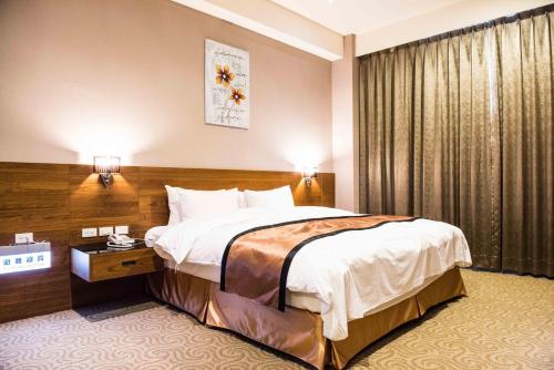 a hotel room with a large bed and a window at Jade Garden Hote in Gukeng