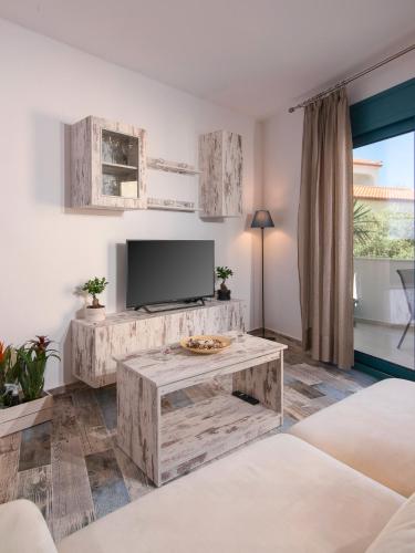 a living room with a television and a table at Villa Tasos-Potos Thassos in Potos