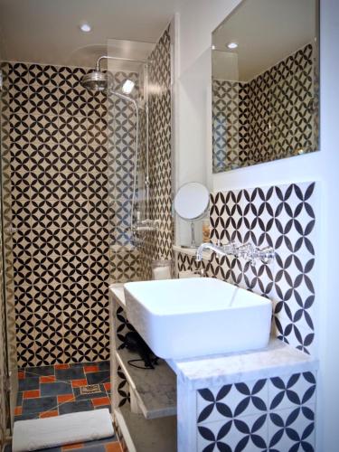 une salle de bain avec un lavabo blanc et un miroir dans l'établissement L'Atelier, à Vence