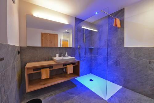 a bathroom with a sink and a shower at Naturhotel Haller in Racines