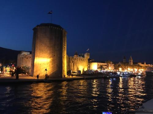 a castle by the water at night at Hostel Marina Trogir in Trogir