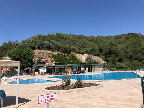 uma grande piscina com uma montanha ao fundo em Ephesus Holiday House em Selçuk