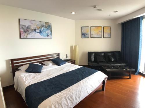 a bedroom with a bed and a black leather chair at The palm wongamat pattaya in North Pattaya