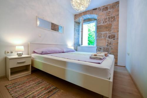 een slaapkamer met een groot bed en een raam bij Mila Apartment in Sinj
