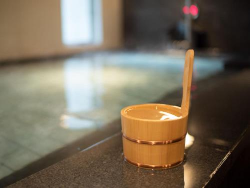 a wooden cup sitting on a table next to a pool at Super Hotel Shinyokohama in Yokohama