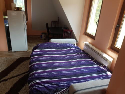 a bedroom with a striped blanket on the wall at Vila Tri Srca in Beserovina