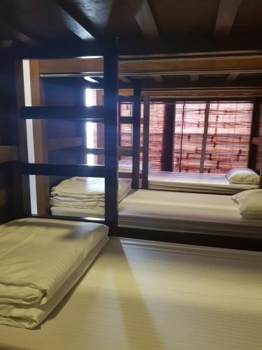 two bunk beds in a room with a window at Micasa Hostels in Puducherry