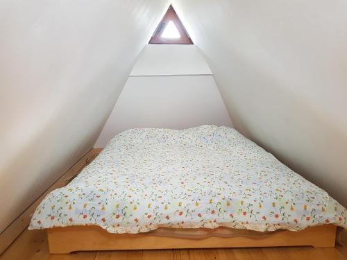 a bed in a corner of a room with a window at Vila Tri Srca in Beserovina