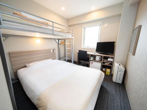 a hotel room with a bed and a bunk bed at Super Hotel Shinyokohama in Yokohama
