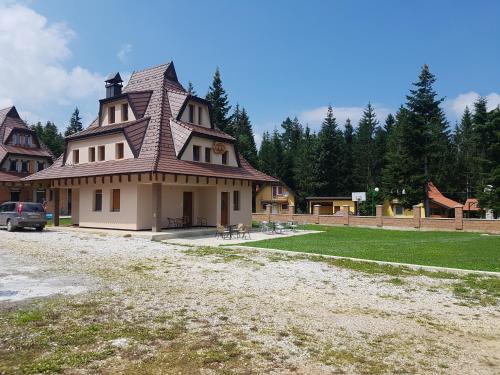 a large house with a turret on top of a yard at Vila Tri Srca in Beserovina