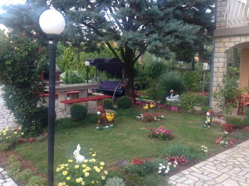 a garden with a picnic table and some flowers at Katy in Krk