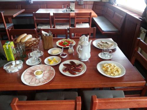 a wooden table with plates of breakfast food on it at Penzion U Zemánků in Jablonec nad Jizerou