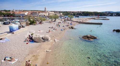 a group of people on a beach in the water at Katy in Krk
