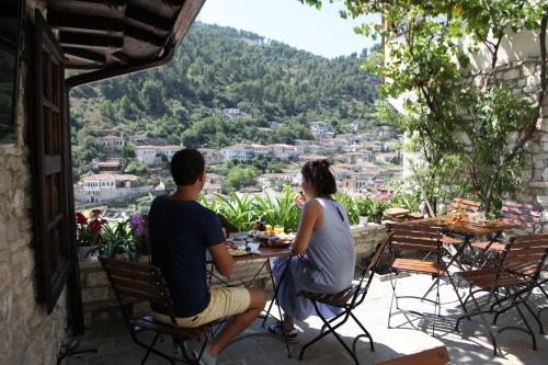 a man and a woman sitting at a table on a balcony at Hani i Xheblatit in Berat