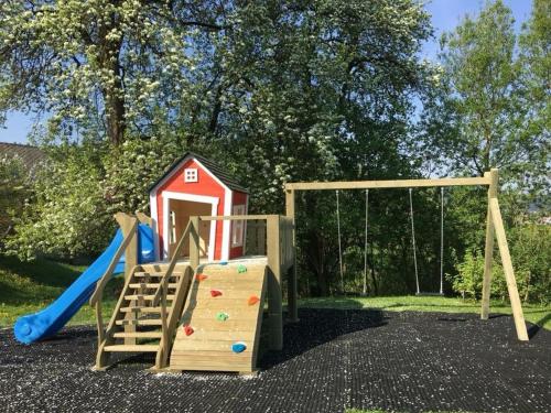 un parque infantil con tobogán y una casa de juegos en Hostel Delalut, en Ravne na Koroškem