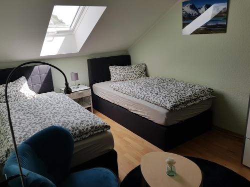 mały pokój z 2 łóżkami i stołem w obiekcie Gästehaus Windheim (Karlsruhe-Knielingen 2) w mieście Karlsruhe