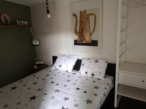 Un dormitorio con una cama con estrellas negras. en De Kade, en Goes