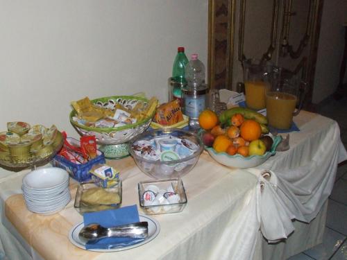 a table with bowls of fruit and other food on it at Hotel Floridiana in Amalfi