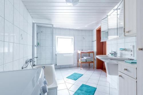 a white bathroom with a tub and a sink at Ferienwohnung Andrea in Pohl