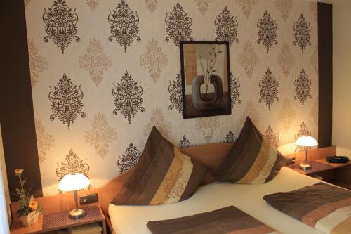 - une chambre avec un lit et 2 tables avec des lampes dans l'établissement Ferienwohnungen Mantke SNF zertifiziert, à Gronau