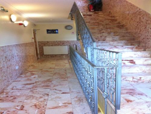 a staircase with marble floors and a metal railing at City Inn Express Hotel in London