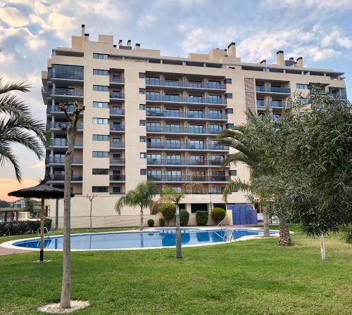 un hotel con piscina frente a un edificio en New apartment in San Juan Playa, Alicante, en Alicante