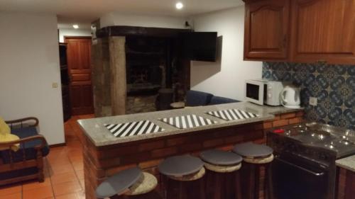 a kitchen with a counter with stools and a stove at Angelas - Casa da Galega in Vila Praia de Âncora