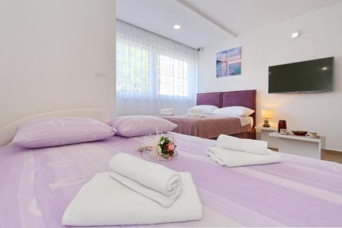 a bedroom with two beds and a flat screen tv at Two new apartments by the town center in Zadar