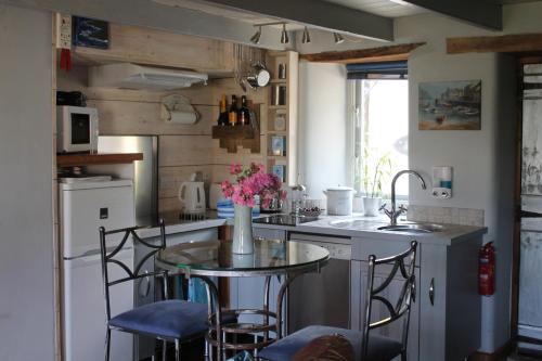 a kitchen with a table with chairs and a sink at Sky Cottage in Fowey