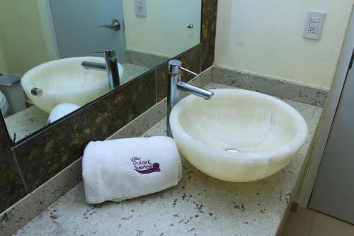 a bathroom with a sink and a toilet and a mirror at Villas Dulce Suenos in Rincon de Guayabitos