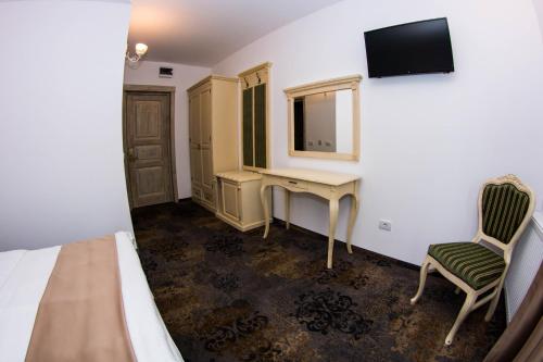a bedroom with a bed and a desk and a television at Vila Seva in Vatra Dornei