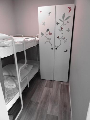 Cette petite chambre comprend une armoire et des lits superposés. dans l'établissement Domaine "Les Hochets, à Vresse-sur-Semois