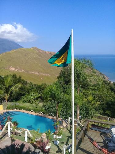 a flag flying in front of a swimming pool at Vila Lia in São Sebastião