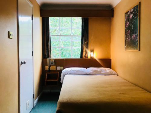 - une chambre avec 2 lits et une fenêtre dans l'établissement The Beverley House Hotel, à Londres