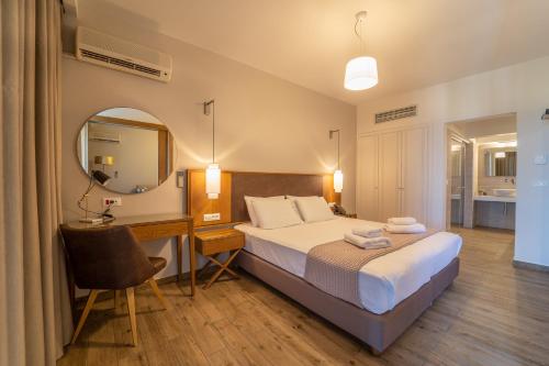 a bedroom with a bed and a desk and a mirror at Achilles Hill Hotel in Methoni