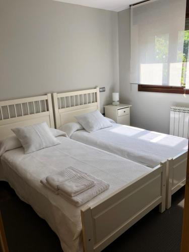 - 2 lits dans une chambre blanche avec fenêtre dans l'établissement Las Hortensias, à Naves