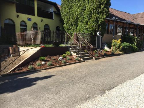 ein Haus mit Garten vor einer Straße in der Unterkunft Fehér Ló Fogadó in Bük