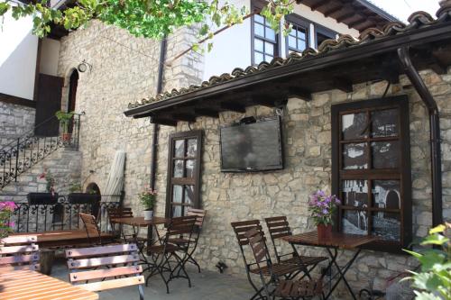 an outdoor patio with tables and chairs and a stone building at Hani i Xheblatit in Berat